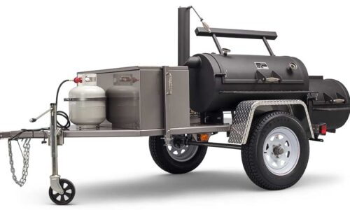 Yoder Smokers Santa Fe mobile cooking machine with over 1,600 square inches of cooking surface, featuring firebox grill grate, sliding top shelf, large prep table, and optional burners