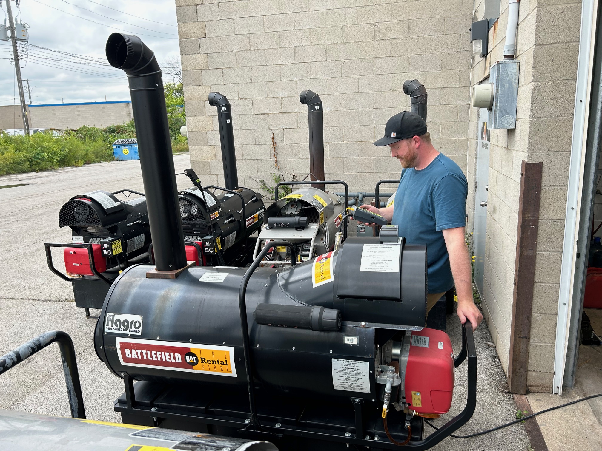 Technician diagnosing a commercial heater using diagnostic tools in a service shop