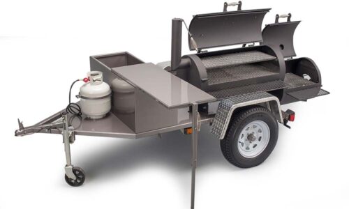 Yoder Smokers Santa Fe mobile cooking machine with over 1,600 square inches of cooking surface, featuring firebox grill grate, sliding top shelf, large prep table, and optional burners