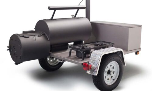 Yoder Smokers Santa Fe mobile cooking machine with over 1,600 square inches of cooking surface, featuring firebox grill grate, sliding top shelf, large prep table, and optional burners